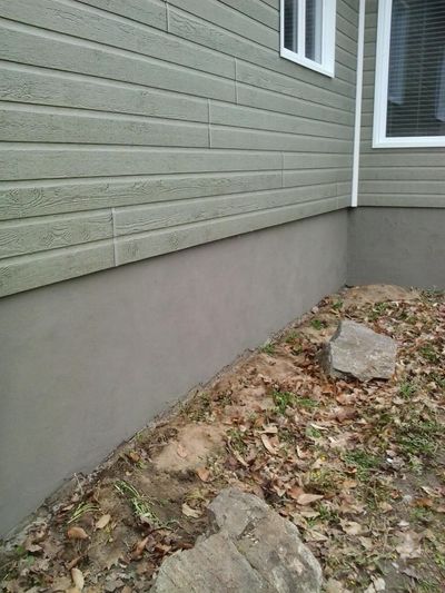 Foundation after completion: cured crépi with a clean sand finish.