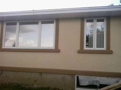 Finished façade: cream acrylic, brown window surrounds and skirt band.