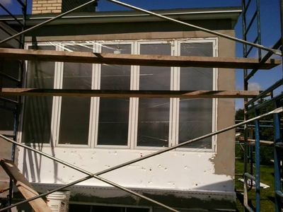 Brown coat applied around the windows, still curing.