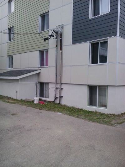 Multi-unit building with foundation finished in white acrylic coating.